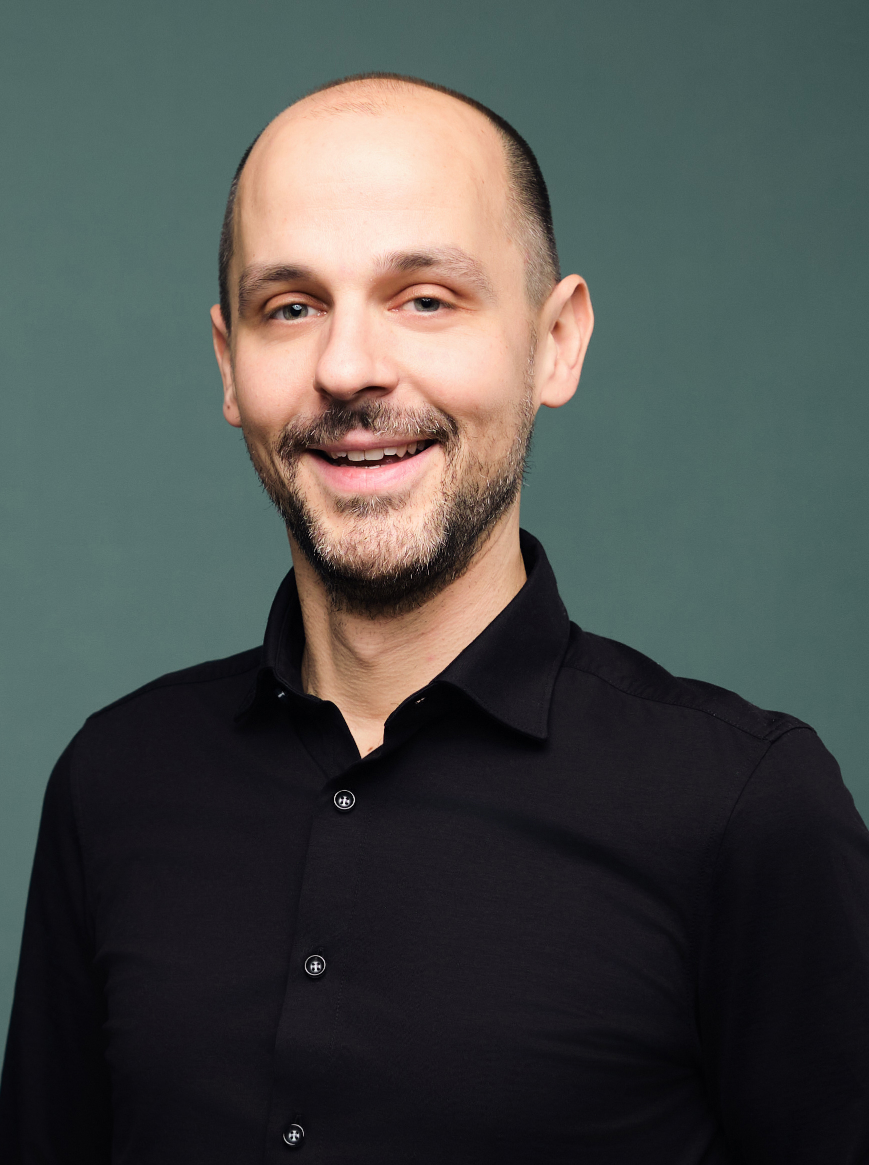 Ein Mann lächelt in die Kamera.