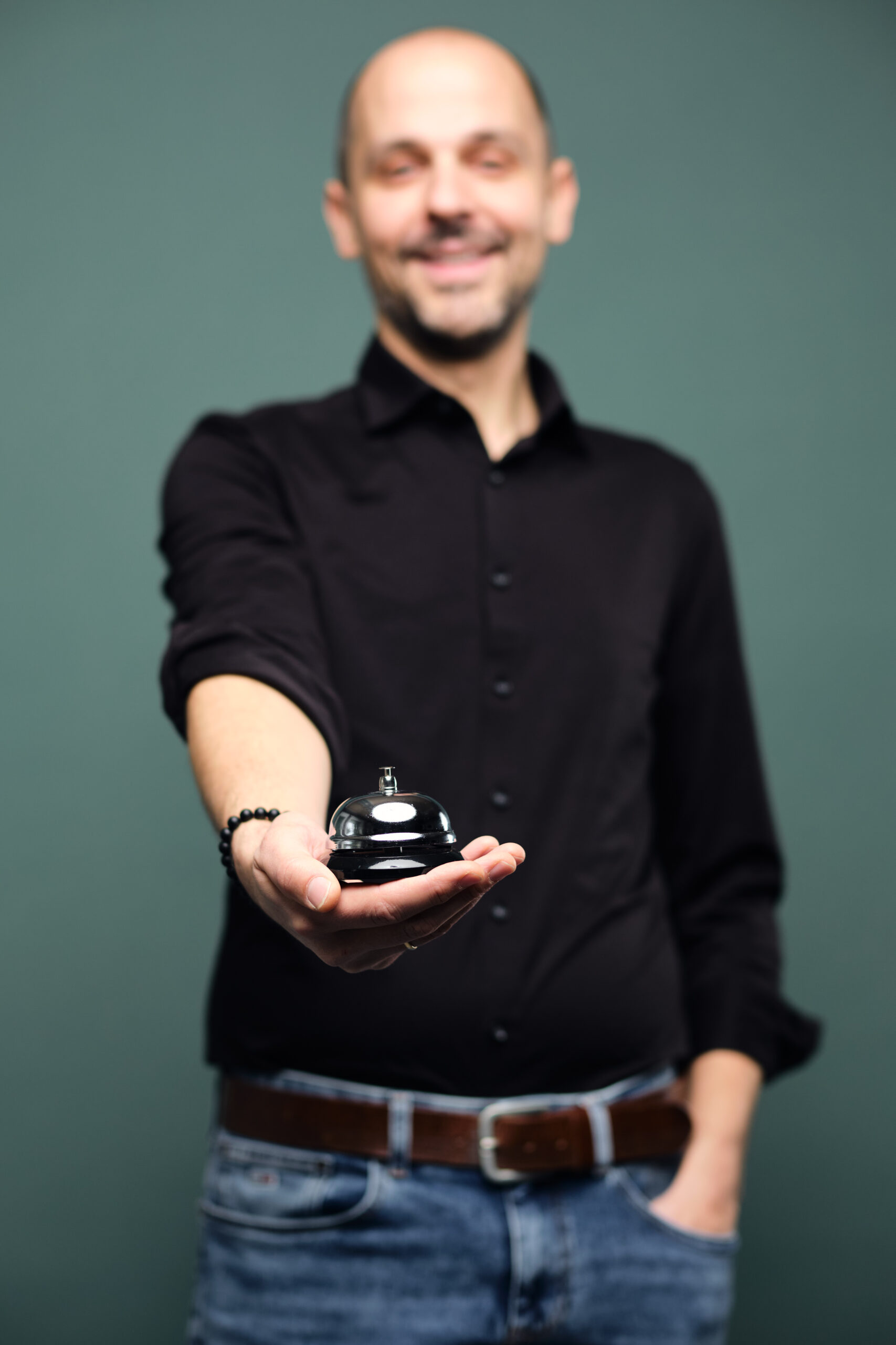 Ein Mann hält eine Concierge-Klingel in der Hand.